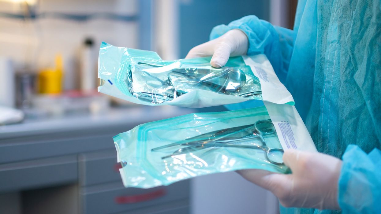 A healthcare professional holds surgical kits.