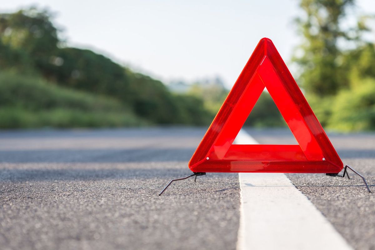 A safety triangle placed on the side of the road.
