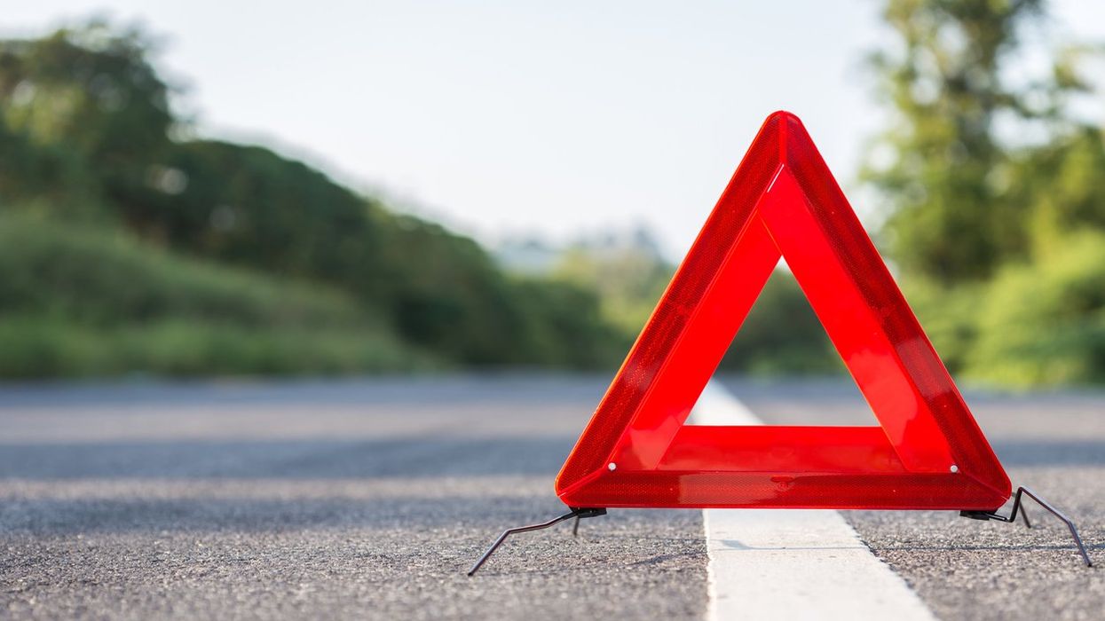 A safety triangle placed on the side of the road.