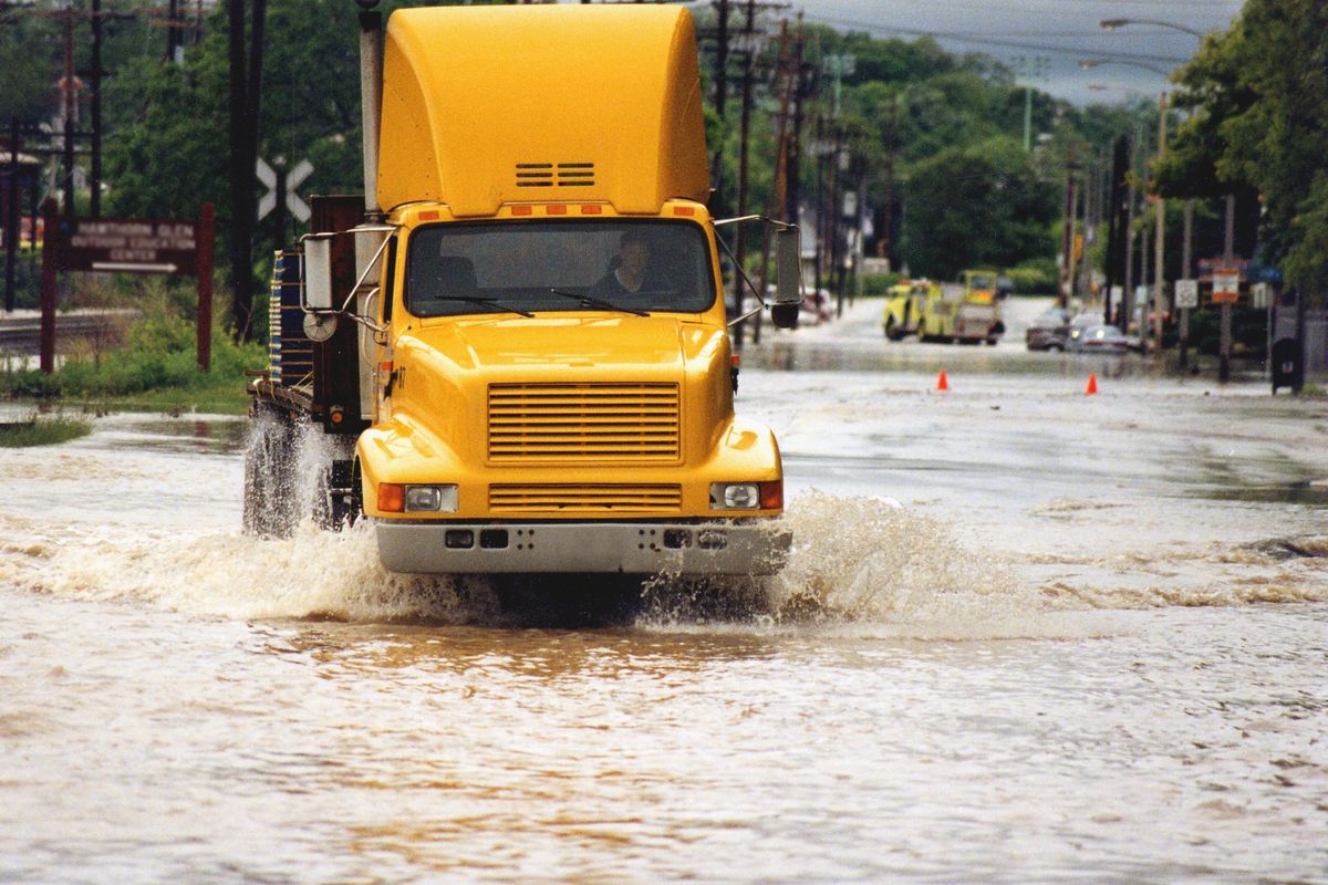 A semi-truck drivers through standing water