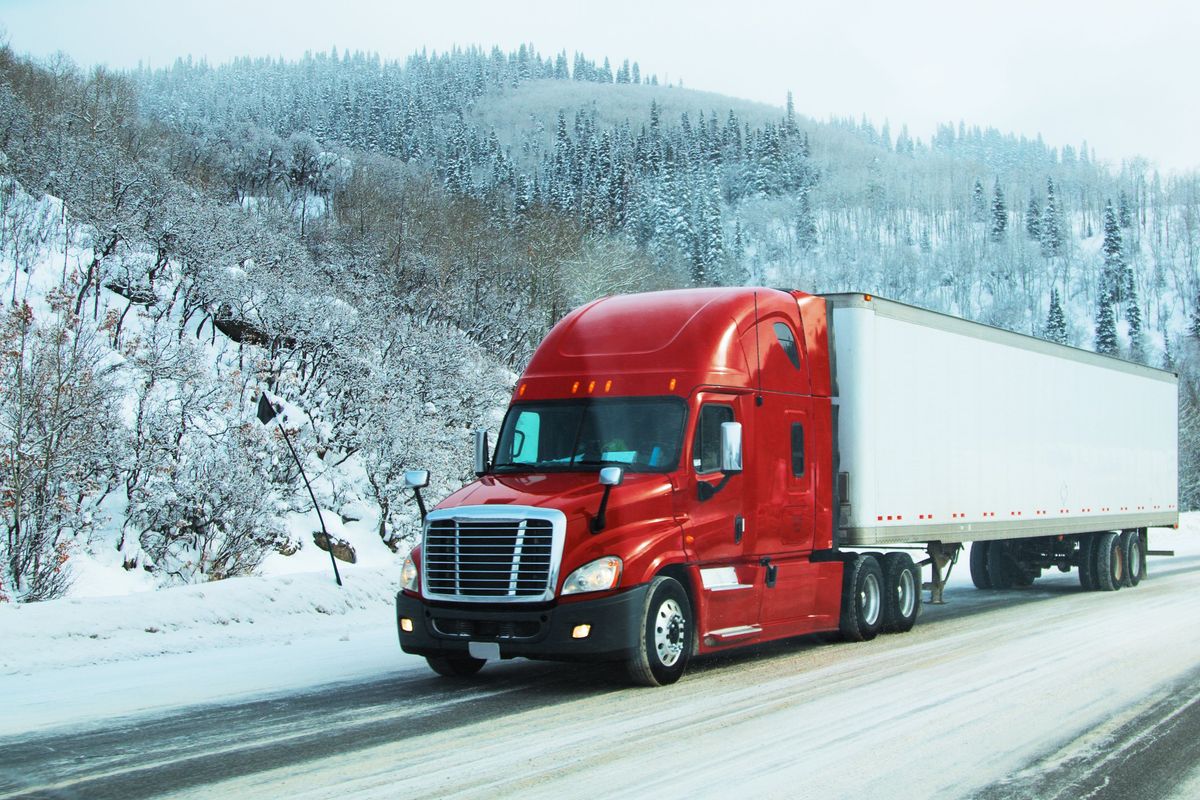 A semi truck driving on a winter road