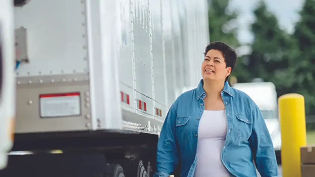 A truck driver conducts a vehicle inspection