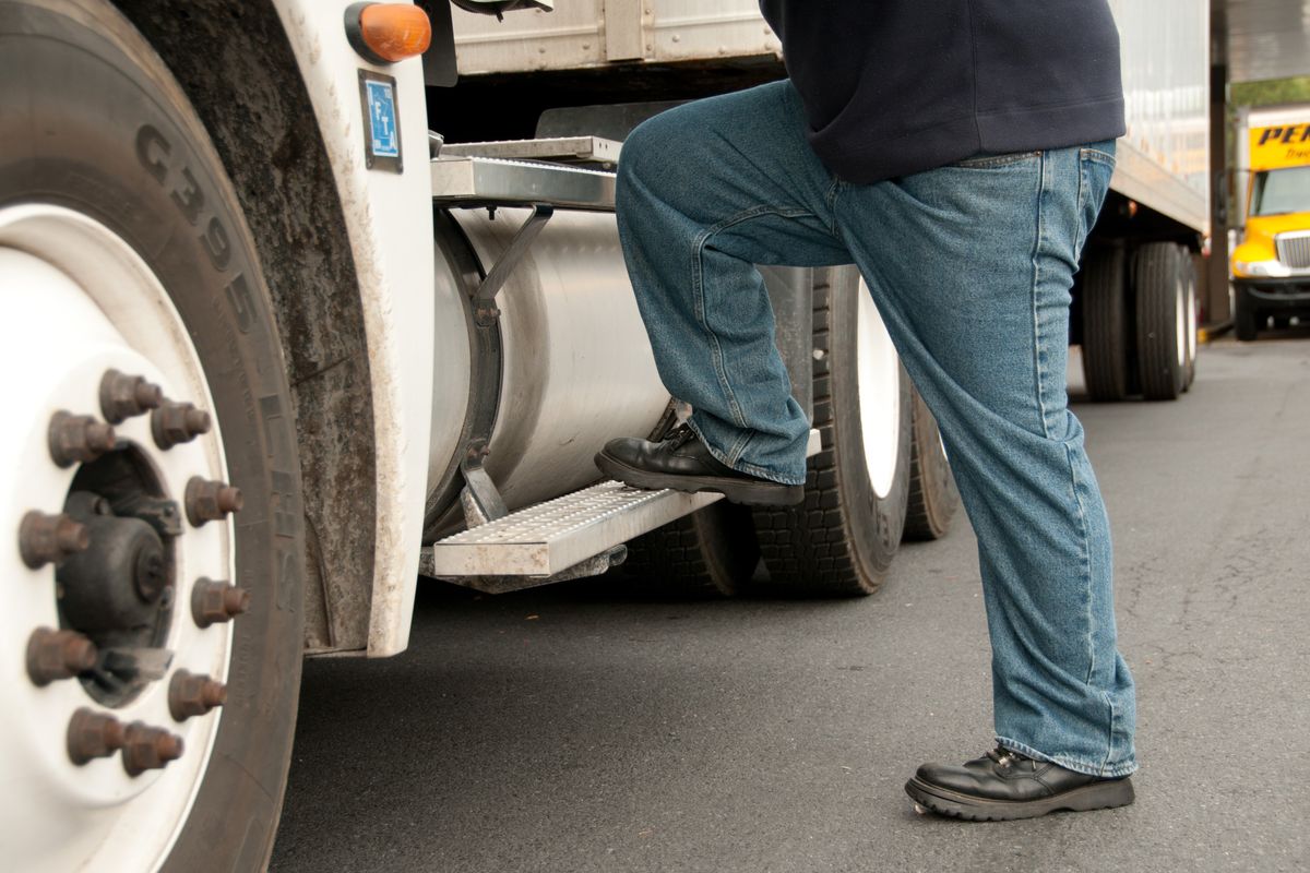 A truck driver steps into a semi truck