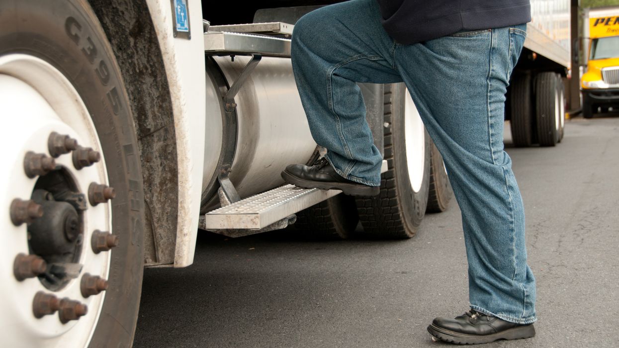 A truck driver steps into a semi truck