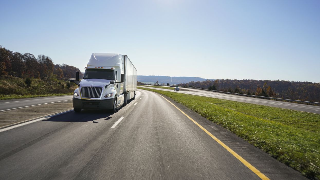 A white Penske semi on the road