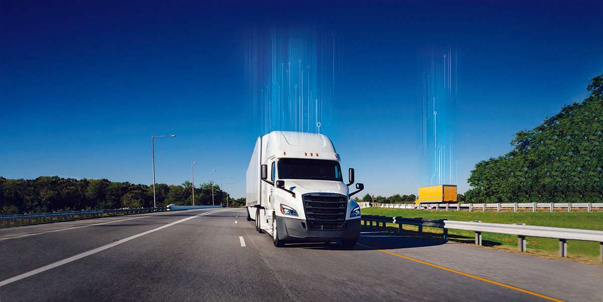 A white Penske semi-truck and yellow Penske box truck drive in opposite directions of a freeway.