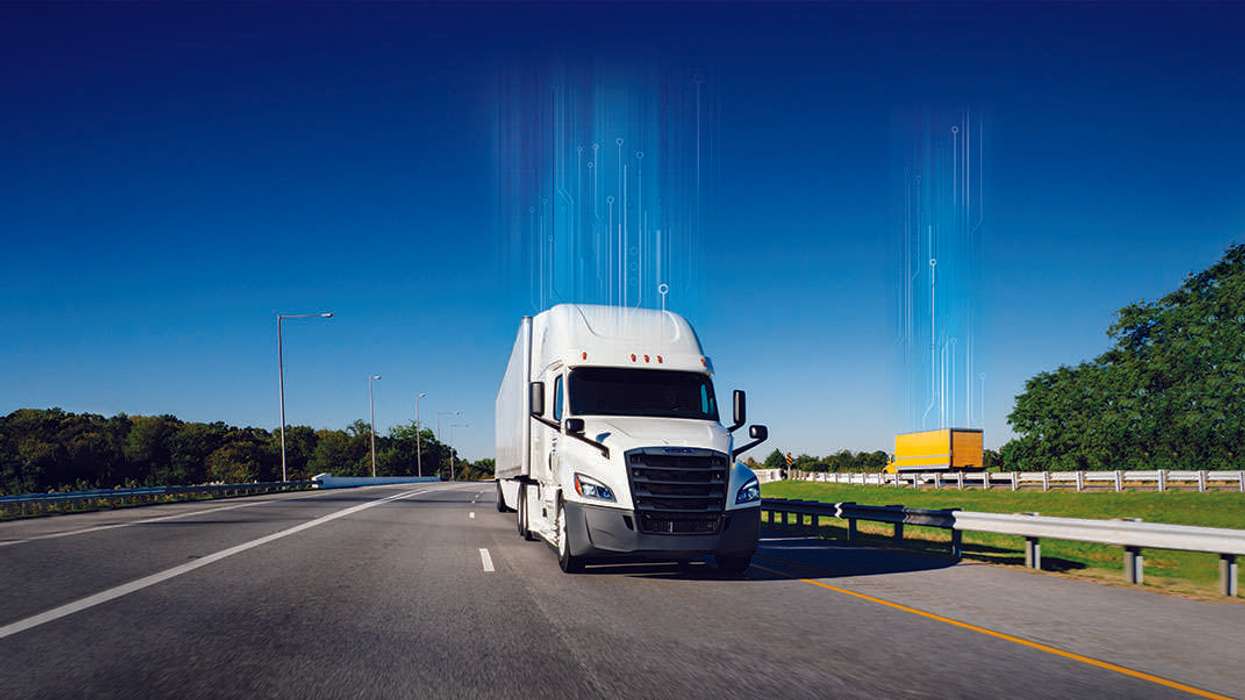 A white Penske semi-truck and yellow Penske box truck drive in opposite directions of a freeway.
