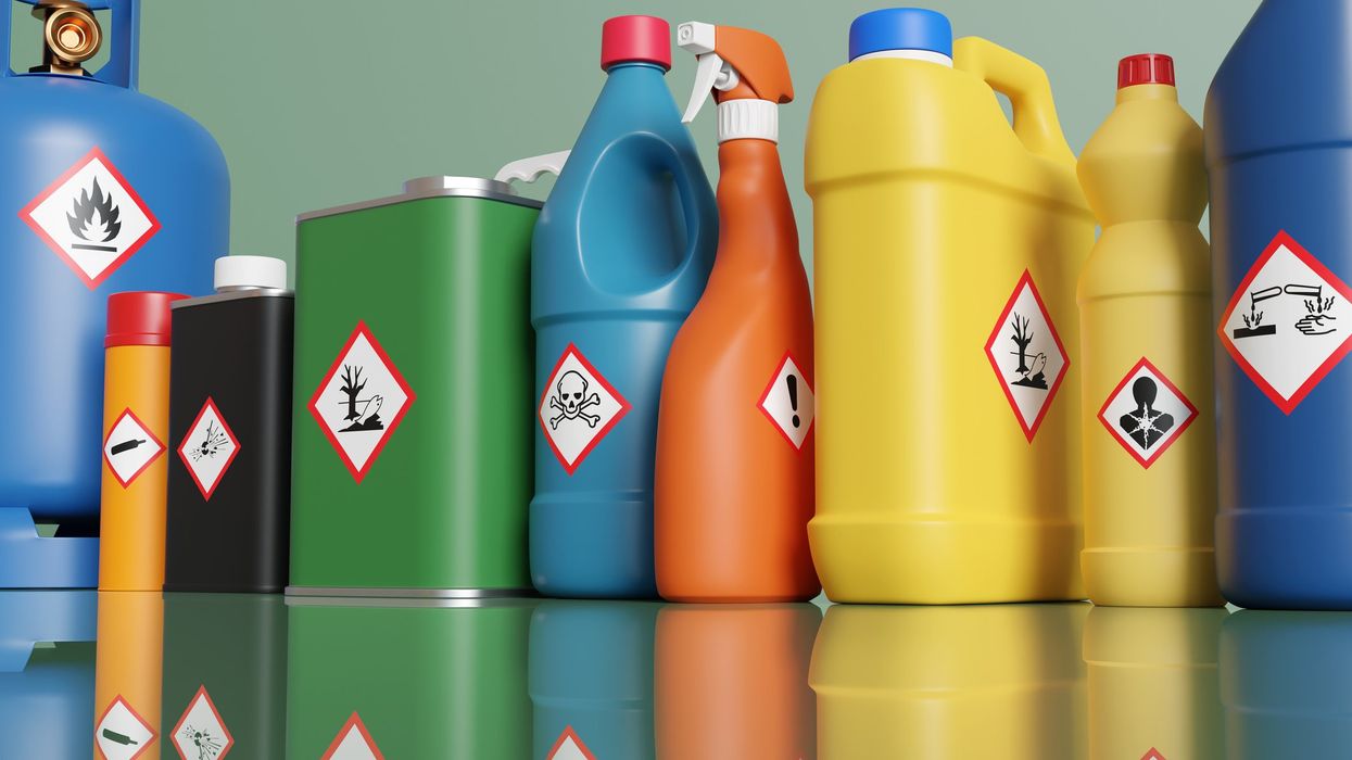 Assorted bottles and propane tanks with hazardous materials labeling on each.