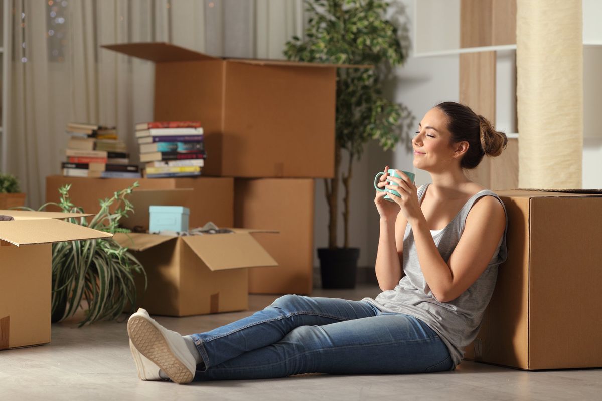 College student relaxing and leaning on packing boxes.