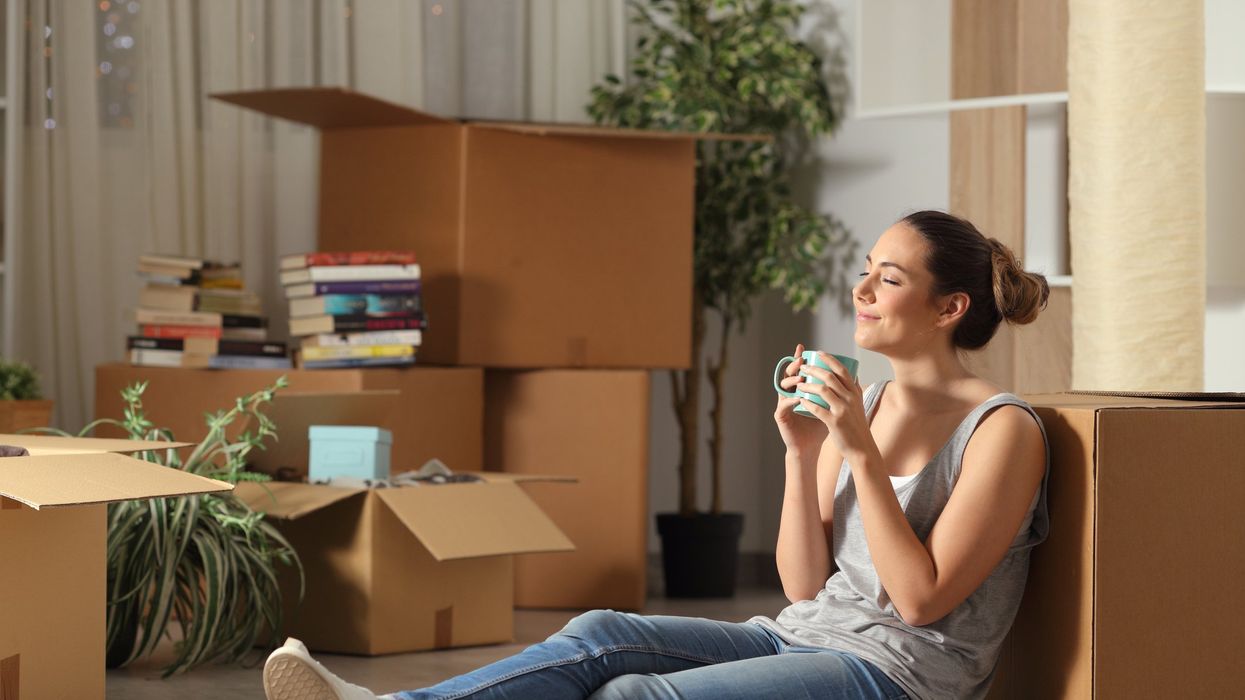 College student relaxing and leaning on packing boxes.