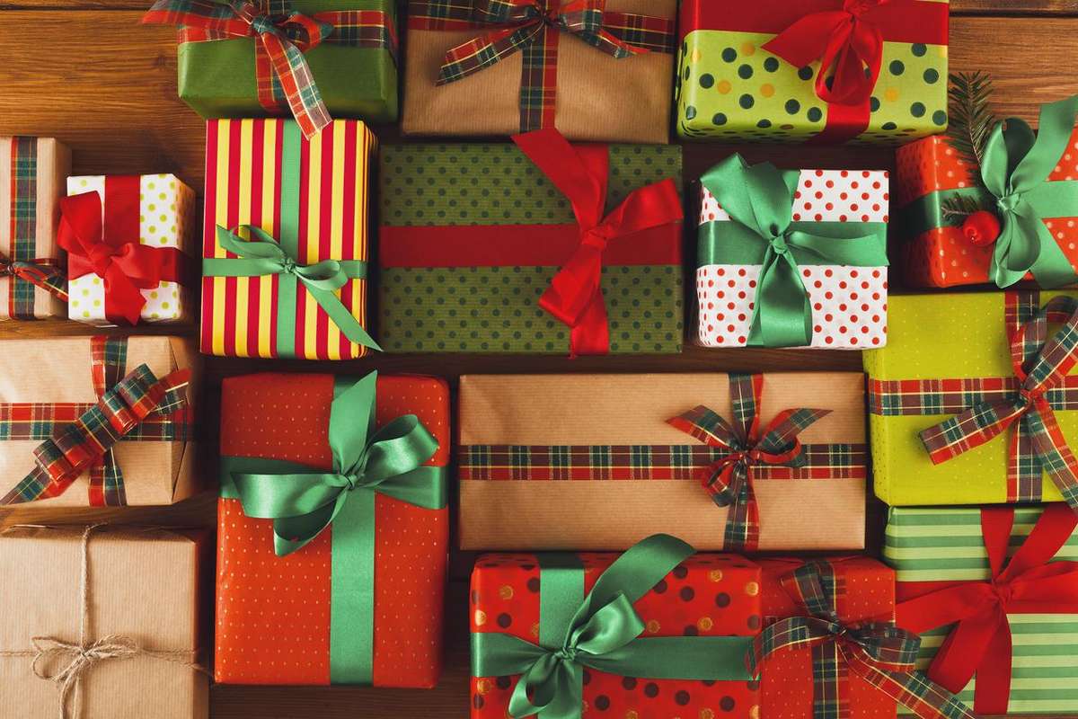 Colorful, wrapped gifts with ribbons arranged on a wooden surface.
