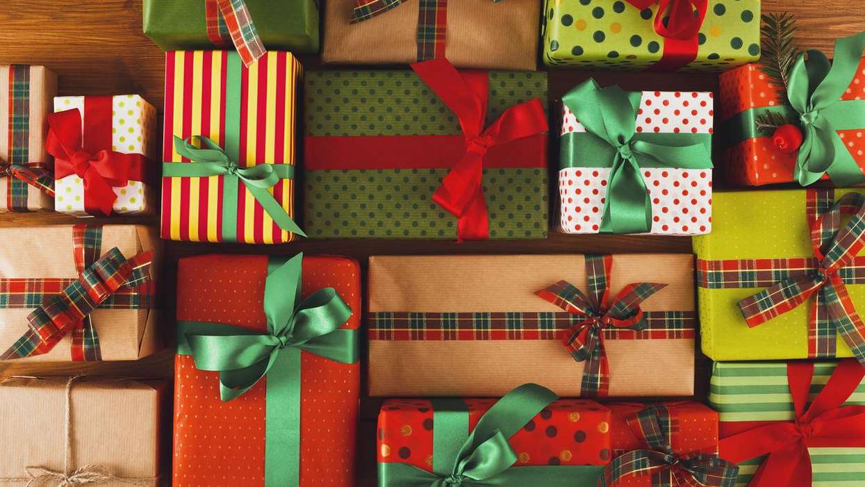 Colorful, wrapped gifts with ribbons arranged on a wooden surface.