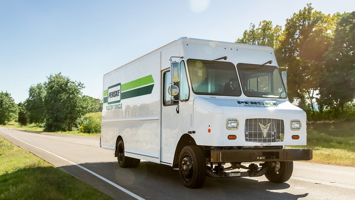 Electric delivery truck driving down the road.