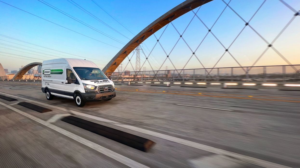 Electric transit van driving across a bridge.