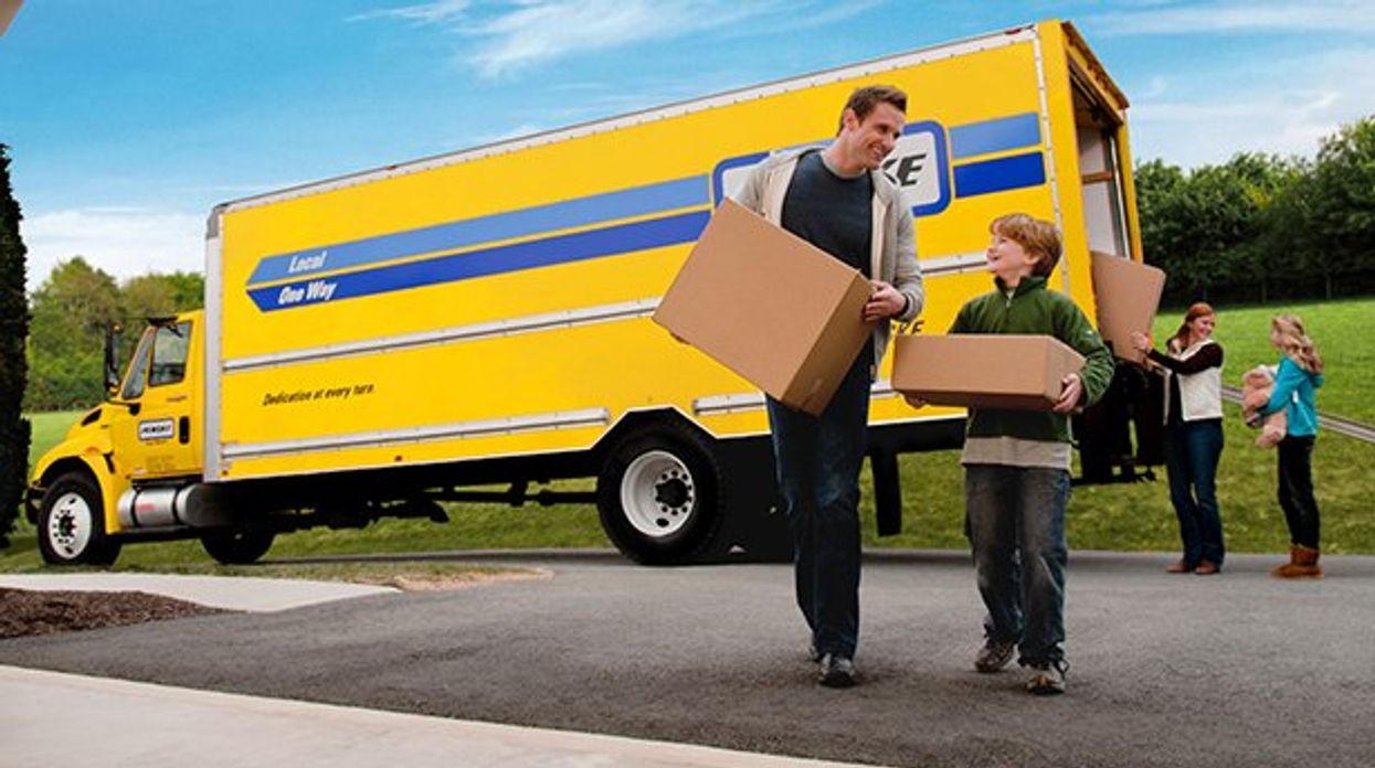 Family unloading boxes from a moving truck.