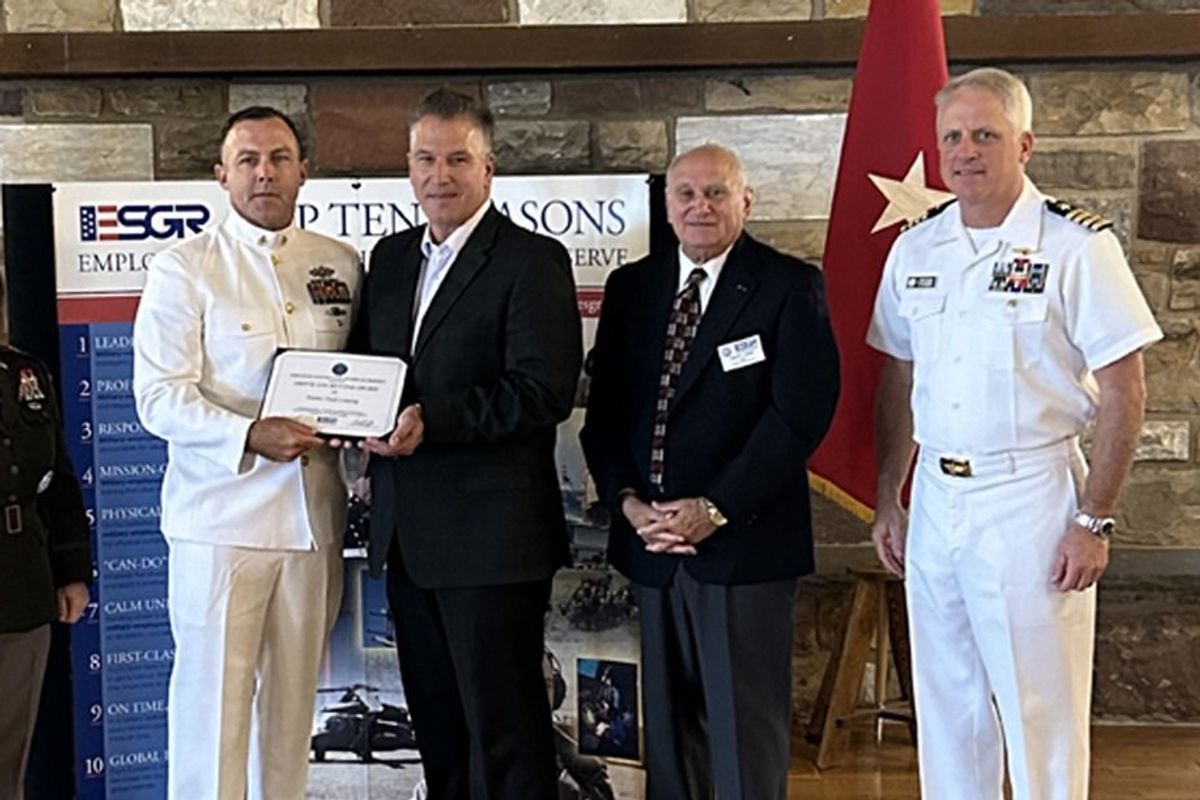 Five people standing together displaying an award.