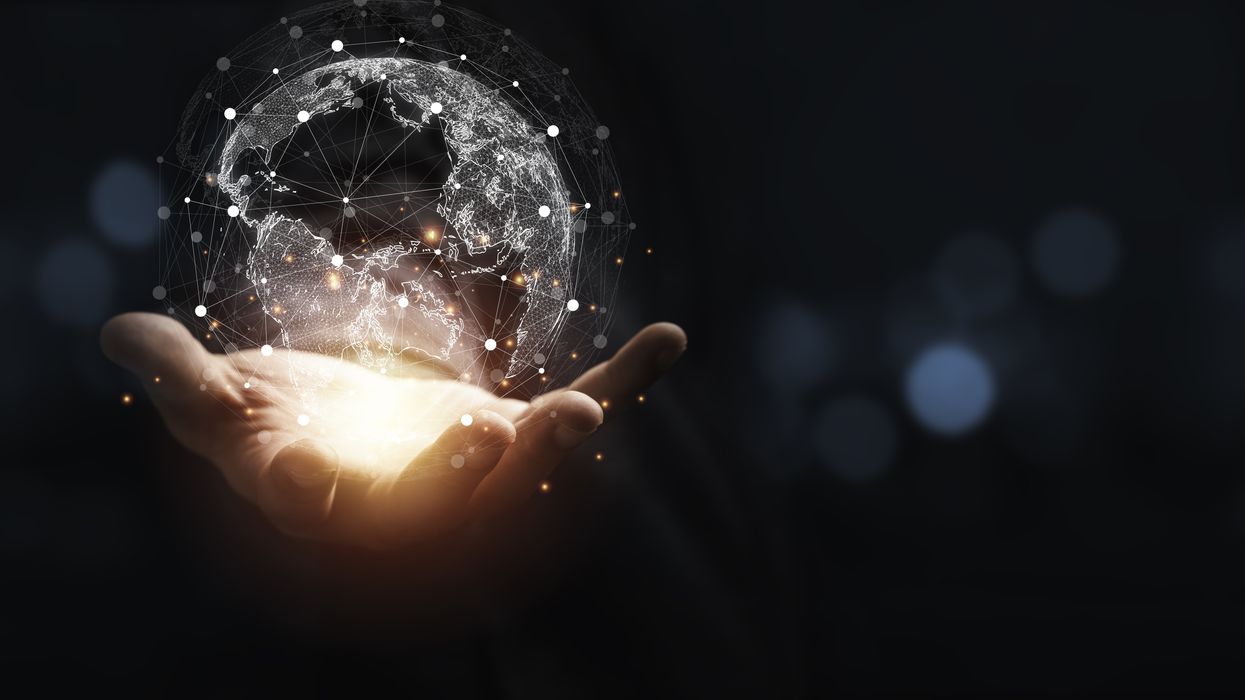 Hand holding a graphic representation of a globe.