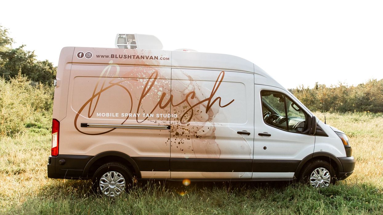 High-roof van parked in a field.