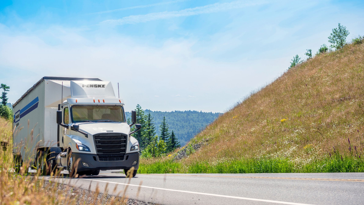 Image of Penske Logistics tractor-trailer driving in springtime scenery.