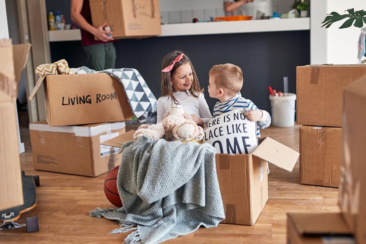 Kids look at home items packed into boxes.
