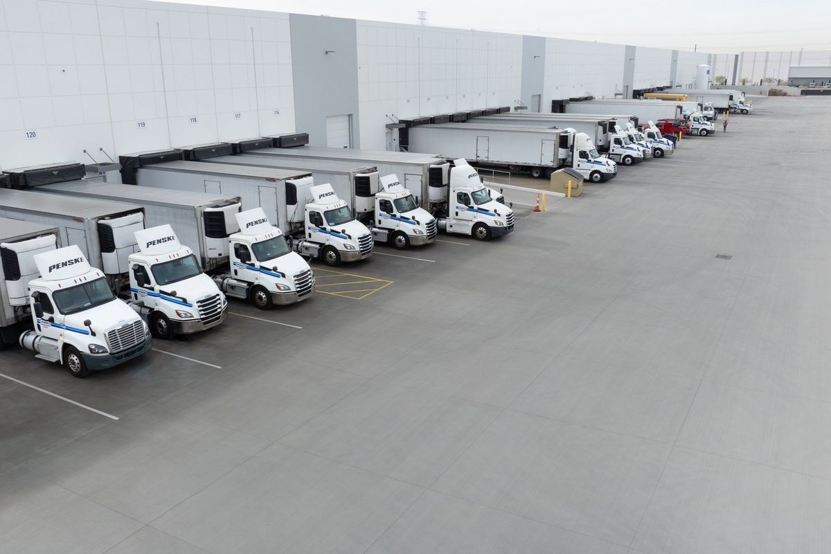 Line of tractor trailers backed up at warehouse docks