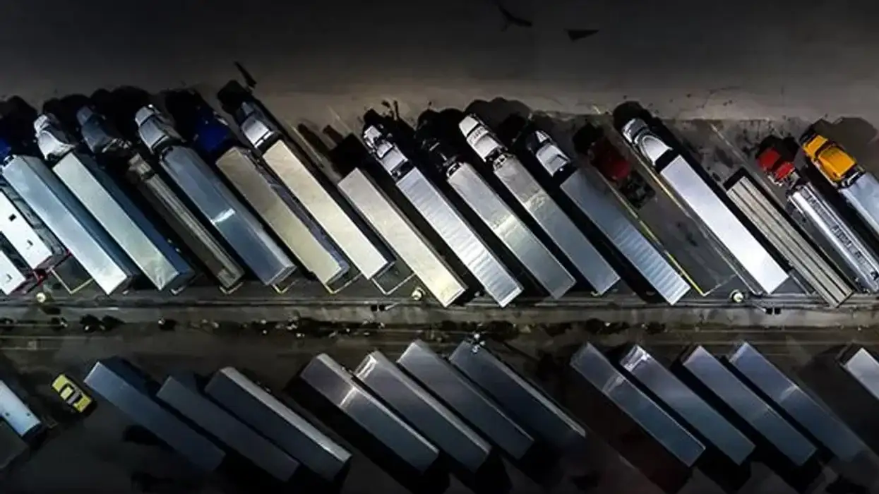 Many semi-trucks parked in a lot