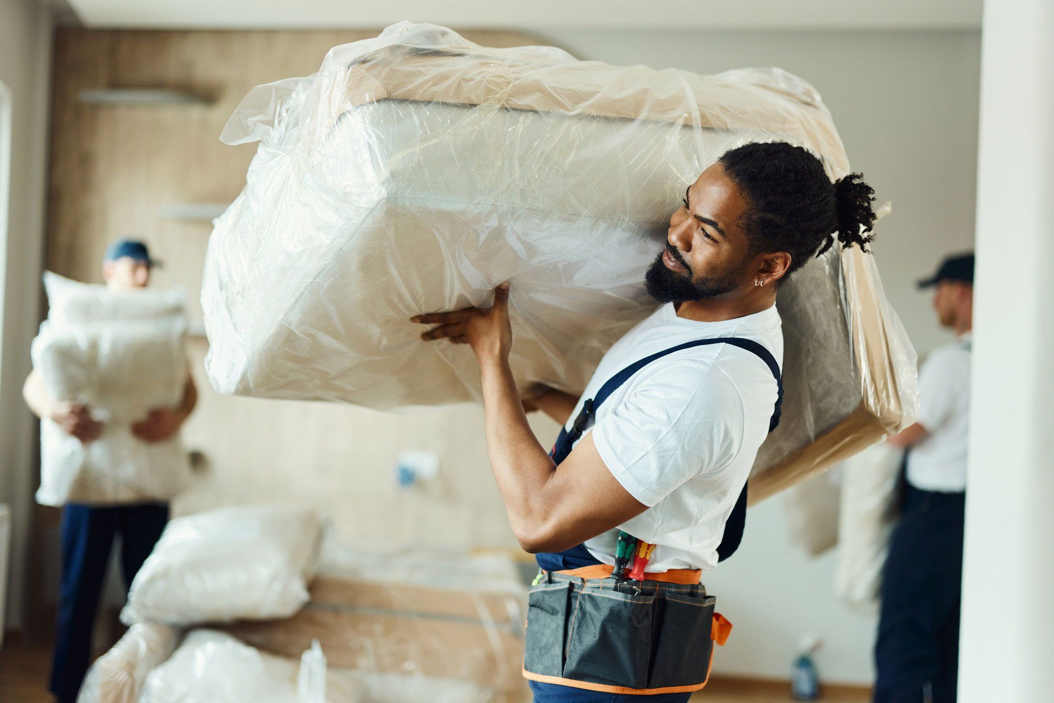 Moving man carrying furniture inside a home.