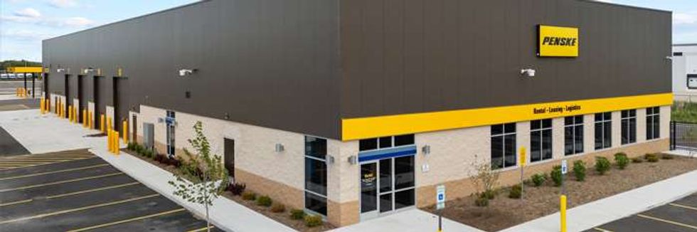 Penske building with garage bays and parking lot, featuring yellow branding accents.