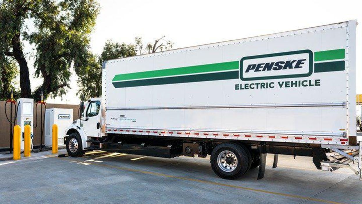 Penske Electric Vehicle in front of charging station