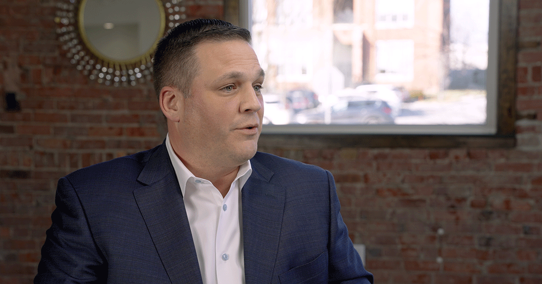 Penske Logistics executive vice president Mike Medeiros in a blue shirt and white button-up.