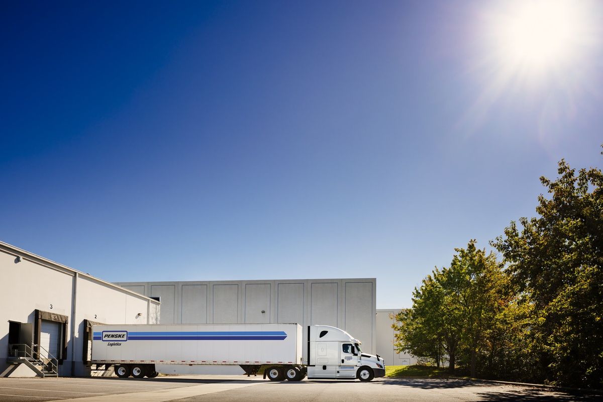 Penske Logistics tractor-trailer backed up to a loading dock.