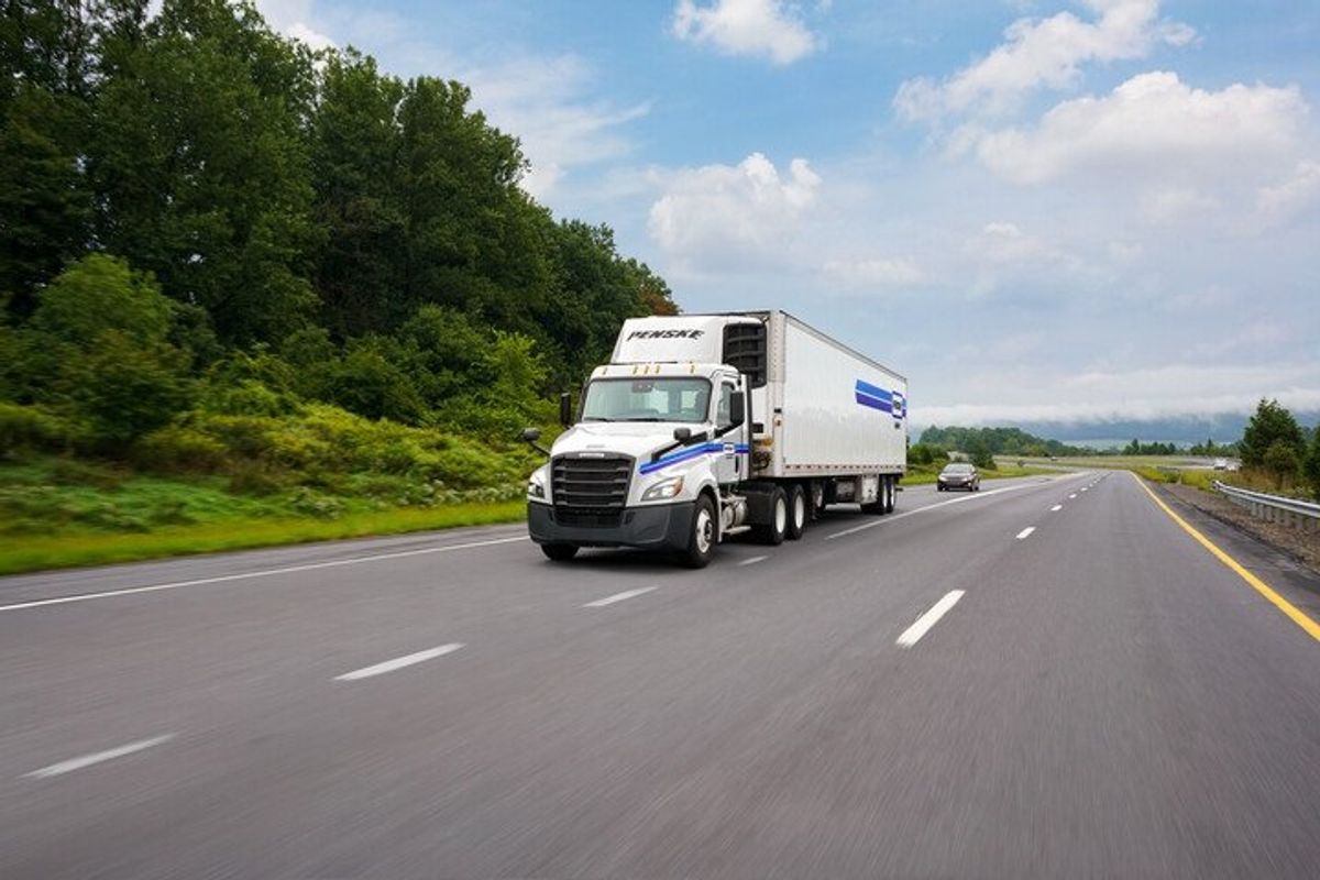 Penske Logistics tractor-trailer driving down the highway.