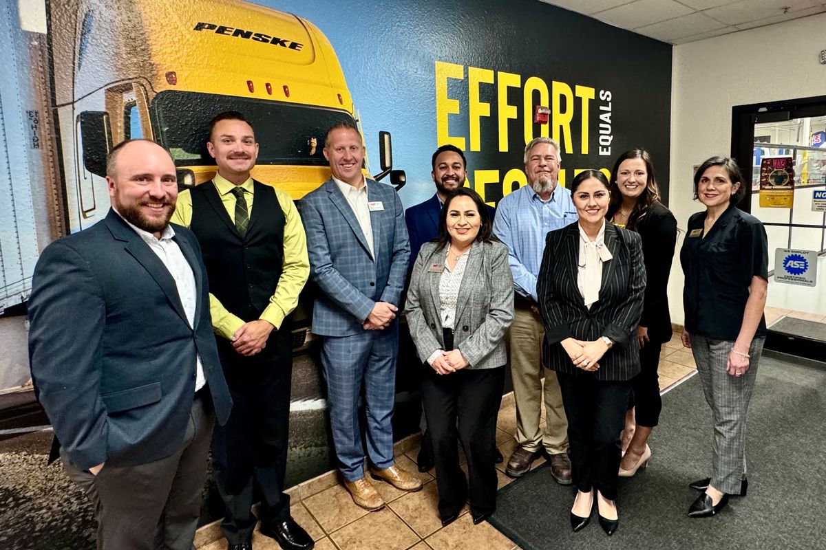 Penske Team and Western Tech Leaders gather for photo in from of Penske-branded wall.