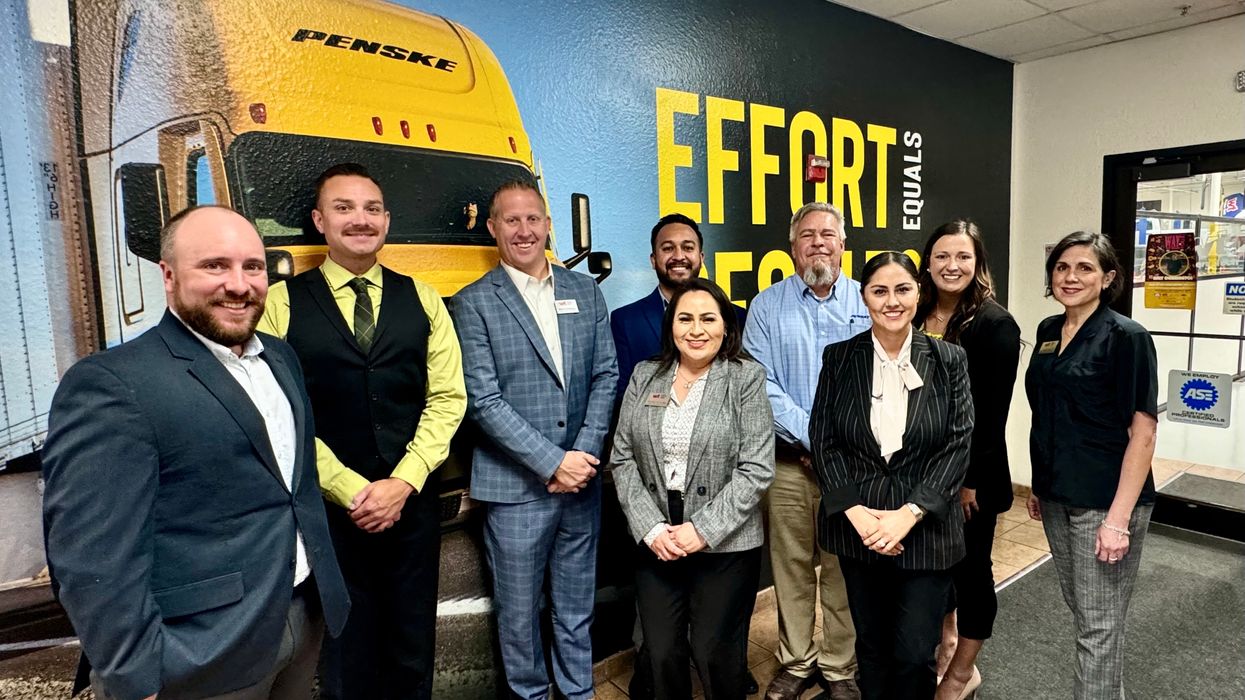 Penske Team and Western Tech Leaders gather for photo in from of Penske-branded wall.