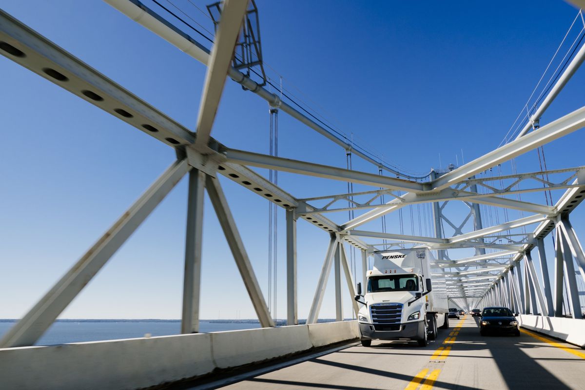 Penske truck driving safely on a bridge