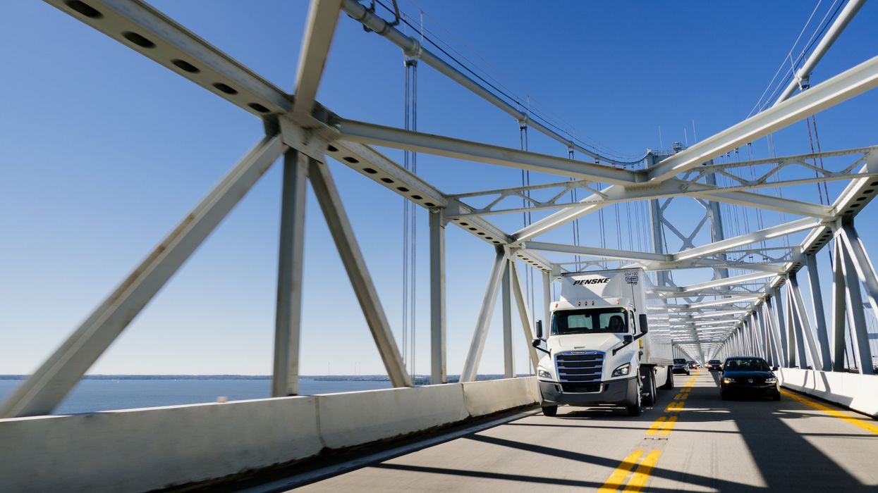 Penske truck driving safely on a bridge