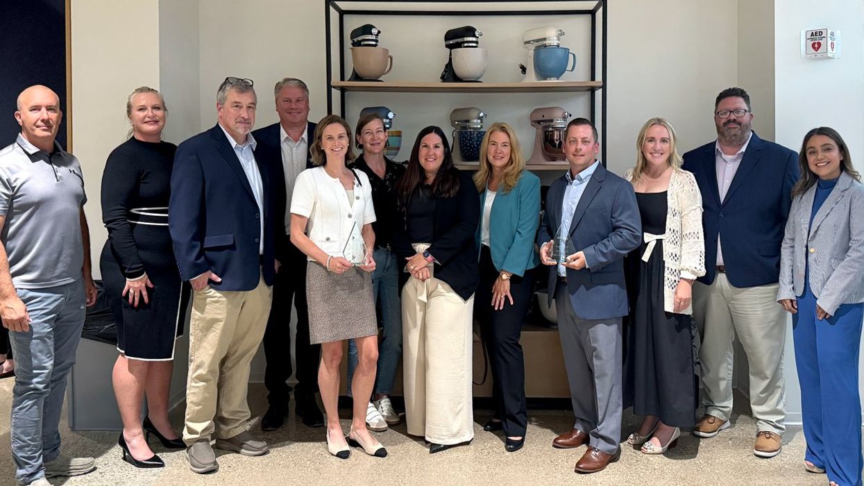 People posing in front of a display of Whirlpool mixers