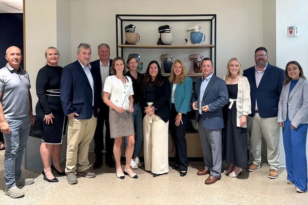 People posing in front of a display of Whirlpool mixers