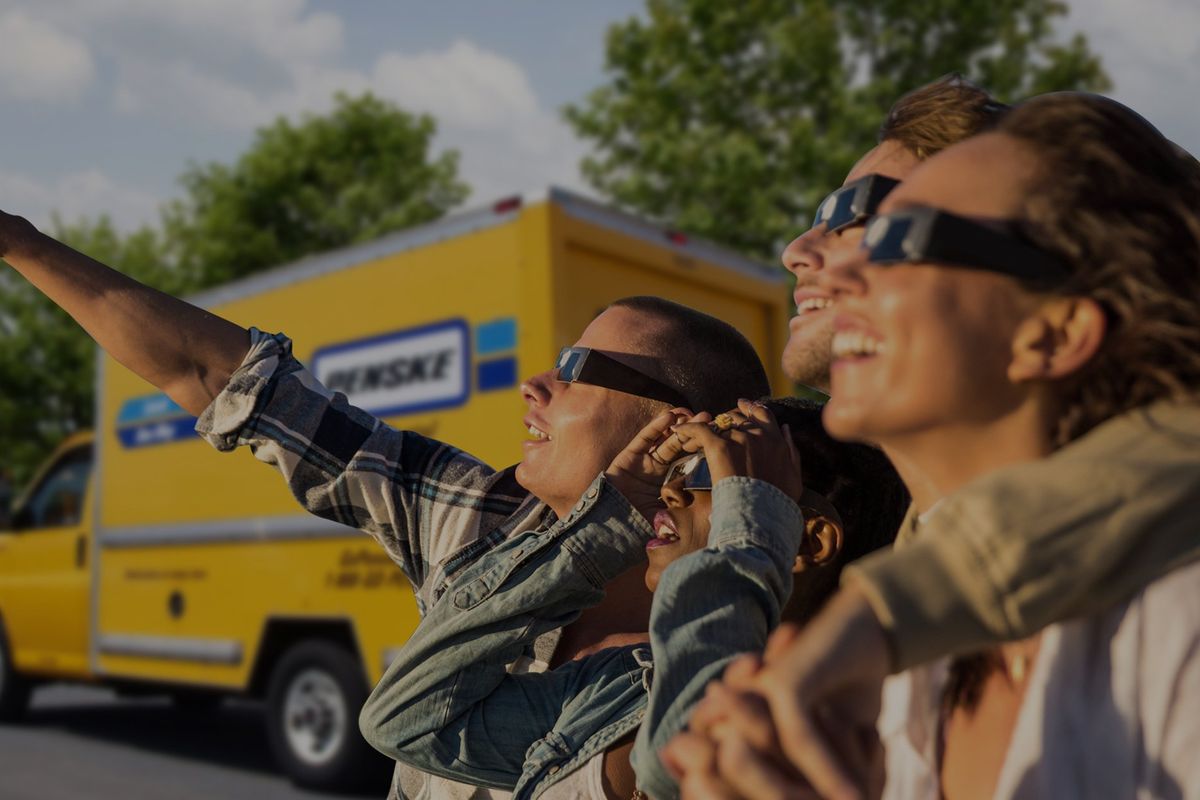 People wearing eclipse glasses and pointing toward the eclipse.