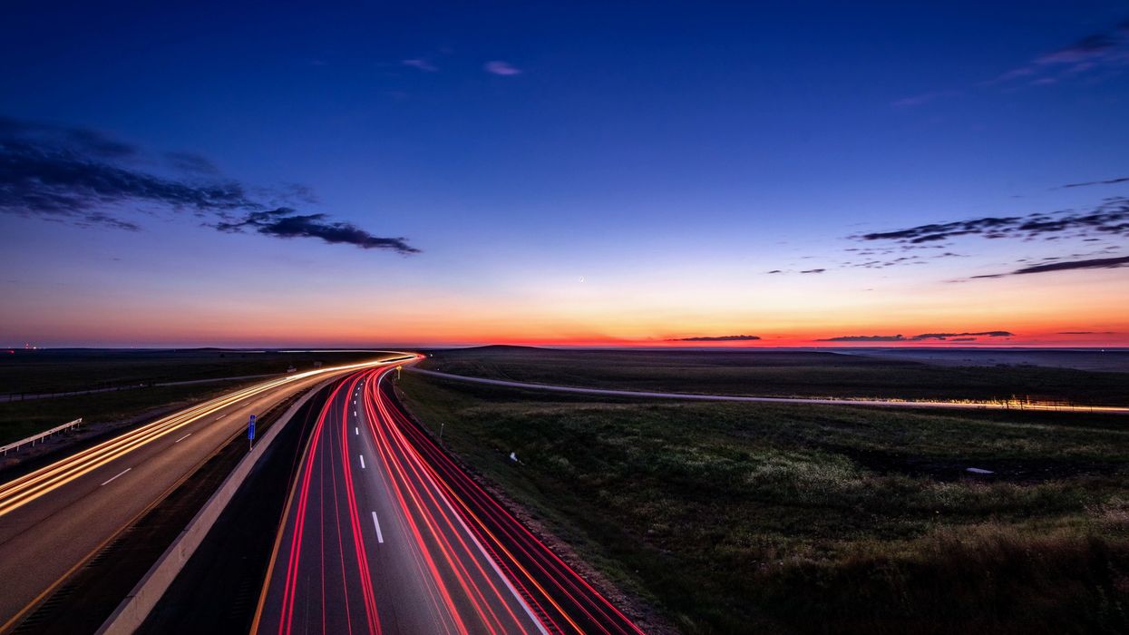 Red brake lights shine brightly on a road at night