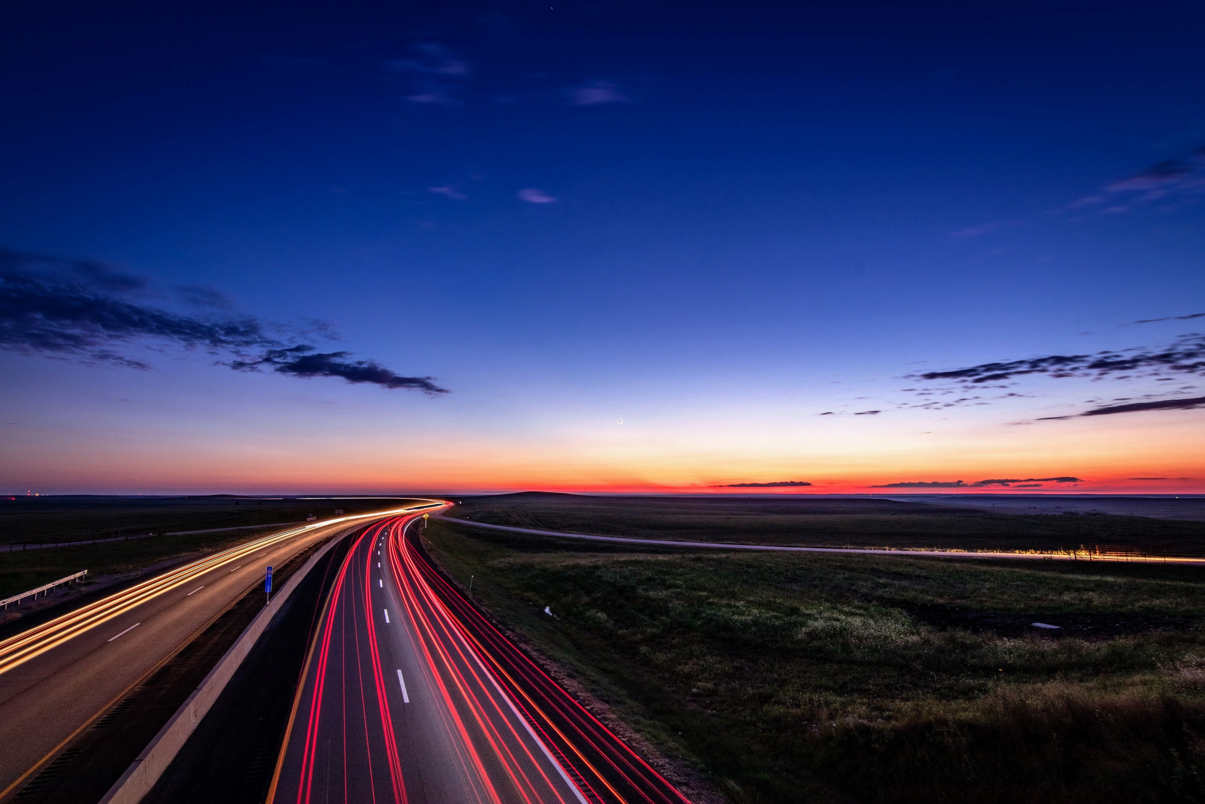 Red brake lights shine brightly on a road at night