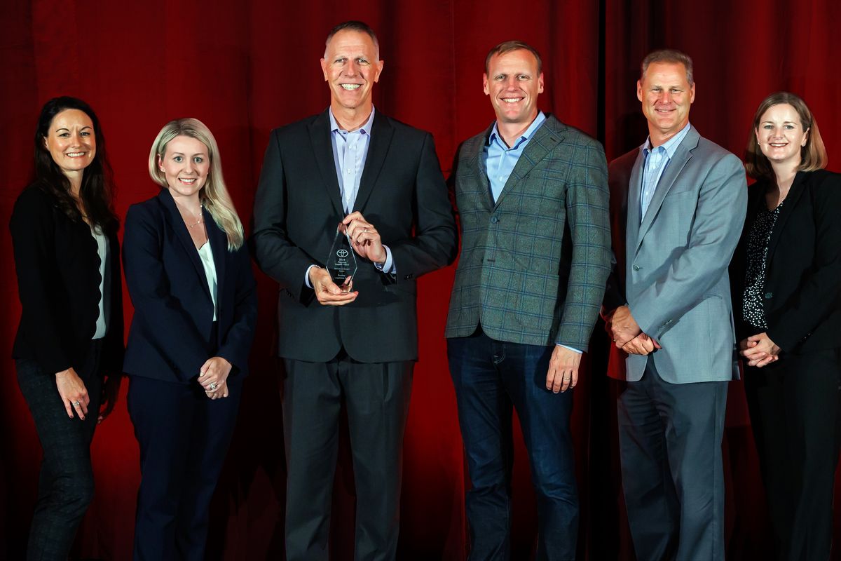 Six people from Penske Logistics posing with an award from Toyota North America