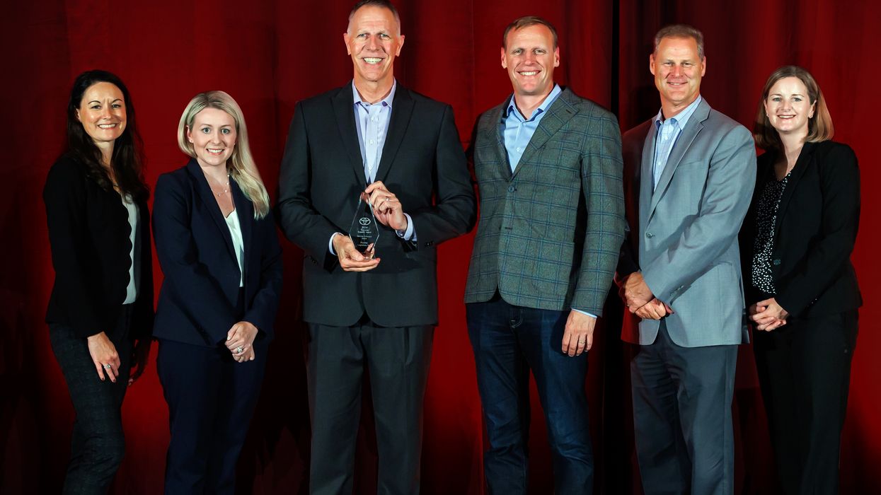 Six people from Penske Logistics posing with an award from Toyota North America