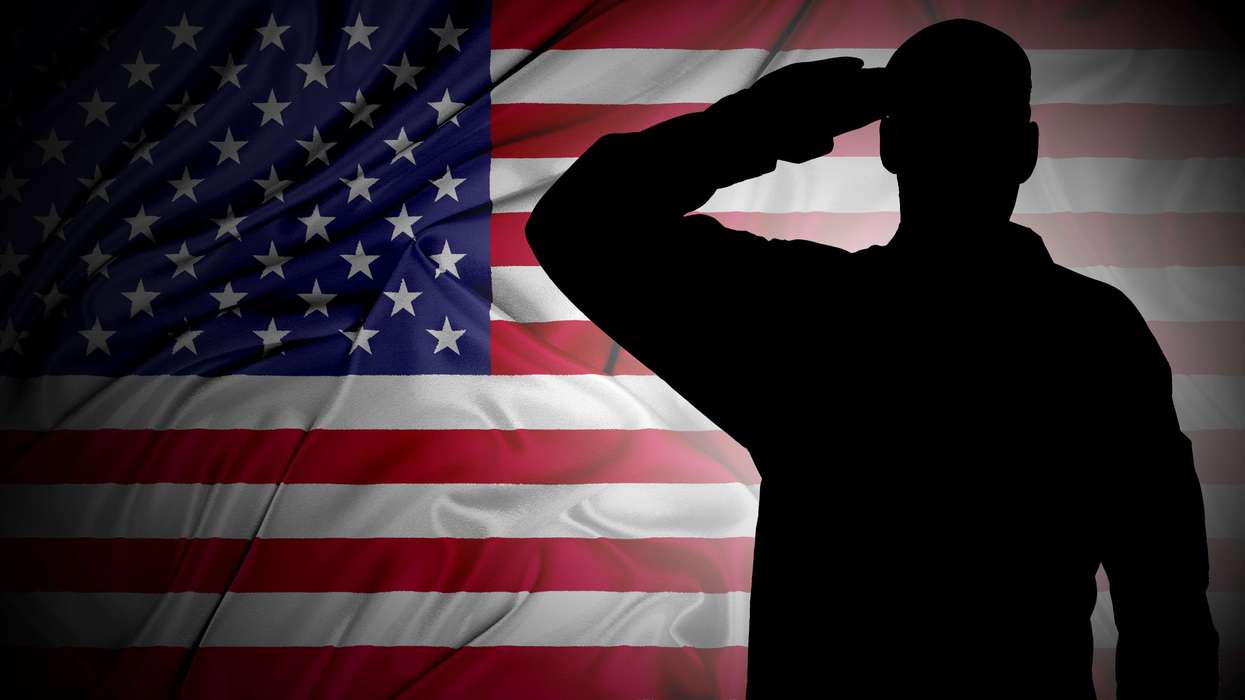 Soldier's saluting silhouette against an American flag