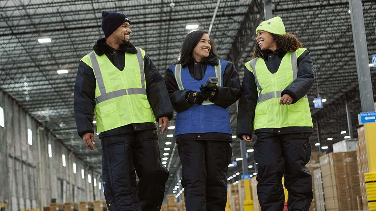 Three warehouse associates walking in a warehouse and talking