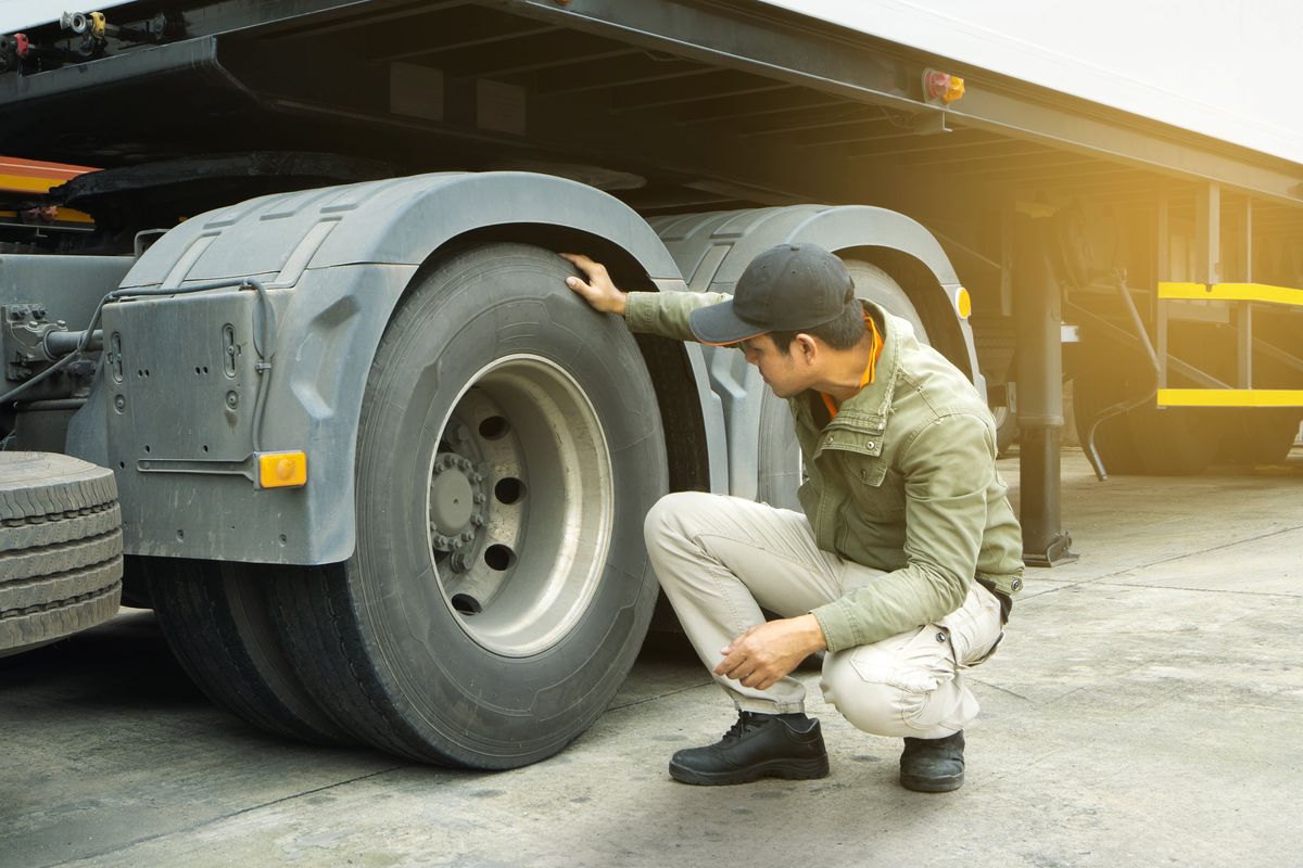 Truck driver inspects truck wheels