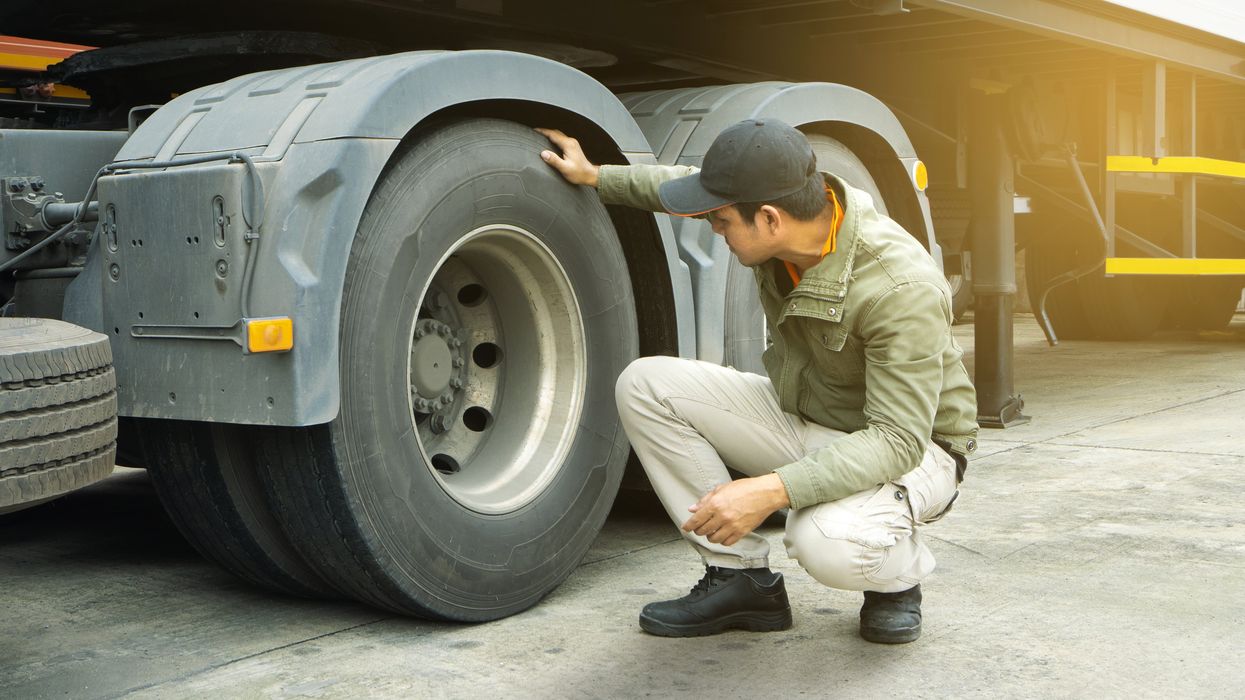 Truck driver inspects truck wheels