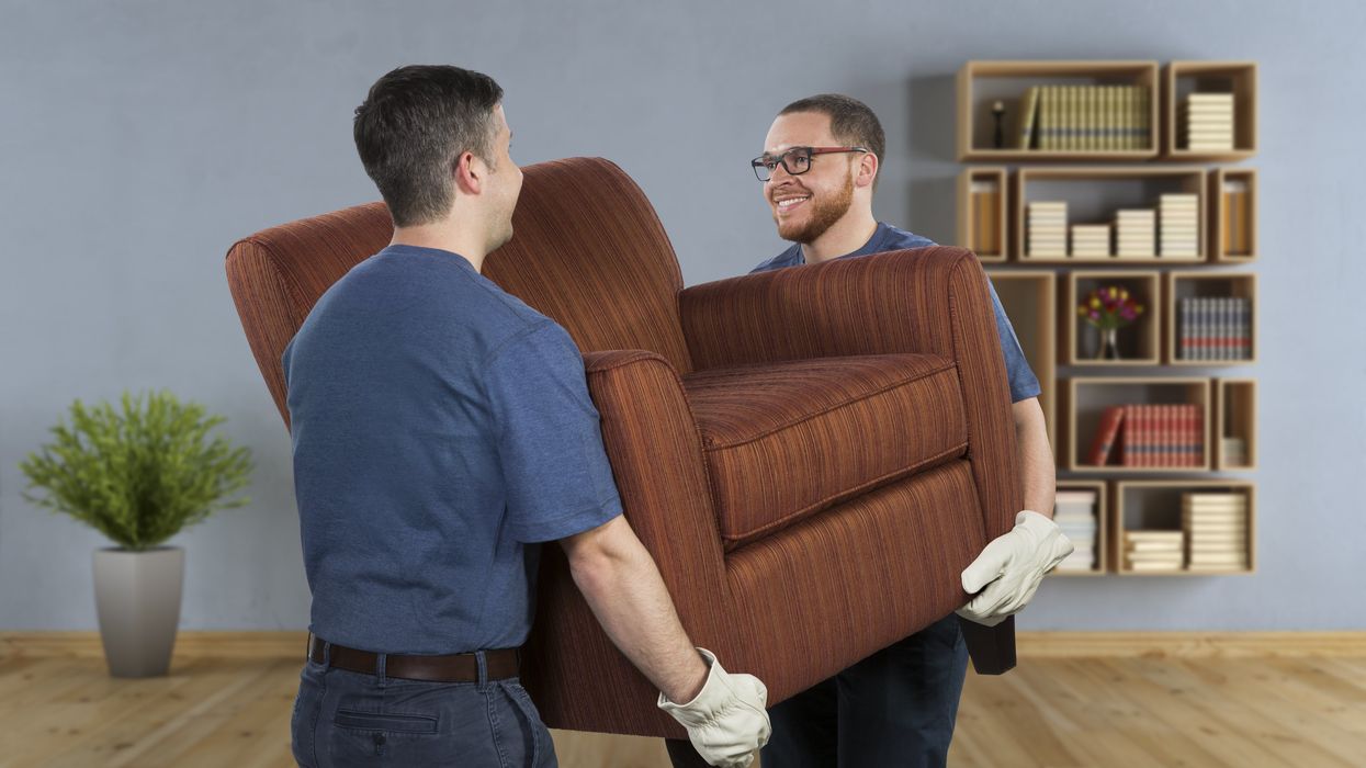 Two men lift a chair