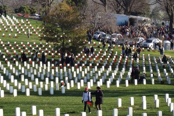 Two people lay wreaths at Arlington National Cemetery