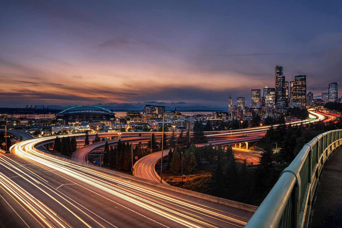 Vehicles speeding down a freeway outside a city at night